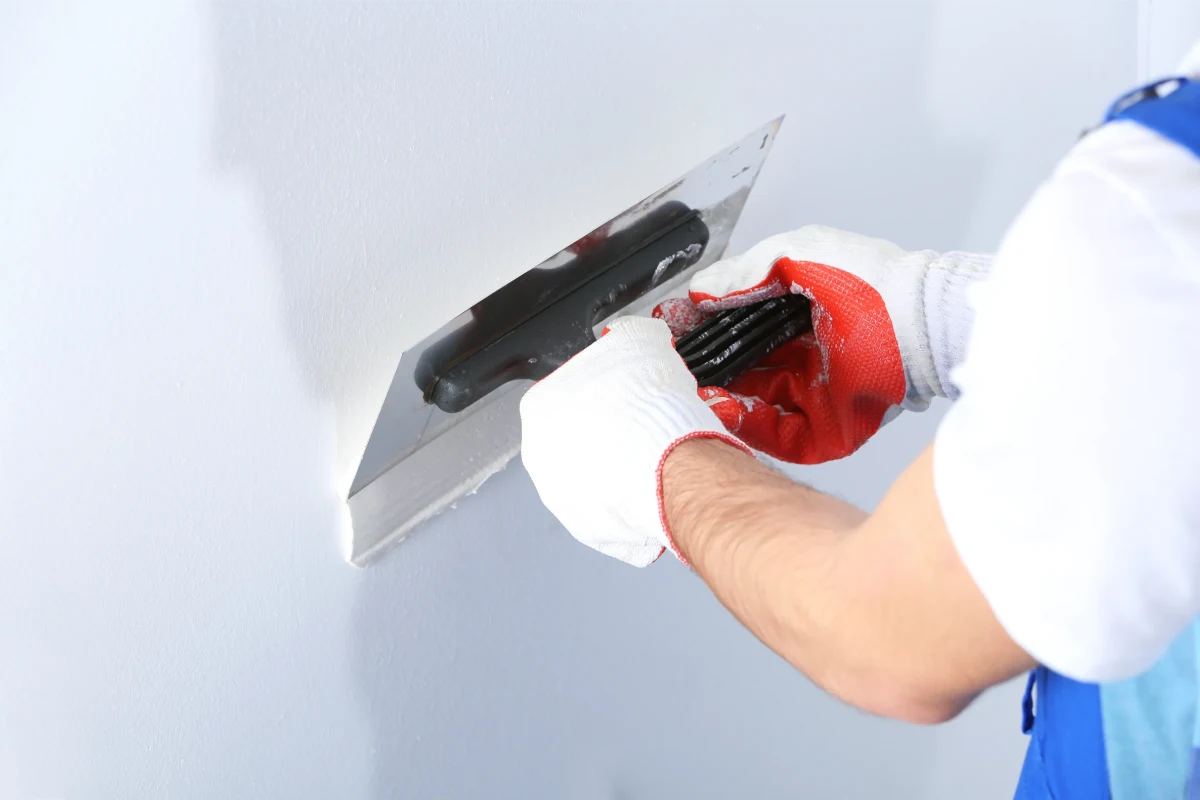 Verputzen und Spachteln der Wand – Malerarbeiten Messie-Wohnung